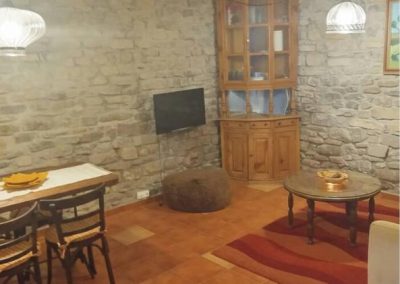 Casa Batán - salón con muros de piedra y mesa de comedor